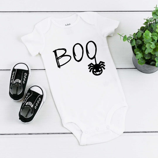White baby romper with black writing saying Boo and spider